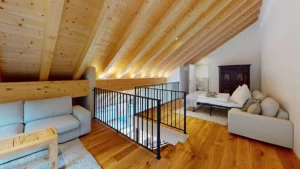 Obergeschoss der Wohnung in Saalbach mit ausziehbarer Schlafcouch und indirekter Beleuchtung auf der Holzdecke