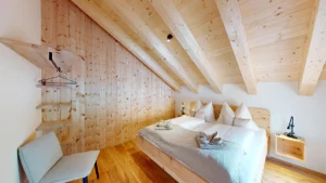 Schlafzimmer mit Zirbenbett, Holzsichtdecke und Wand