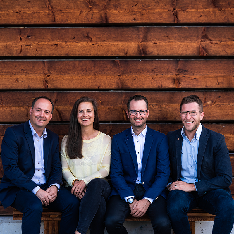 Gesellschafter der Unternehmensgruppe auf einer Holzbank