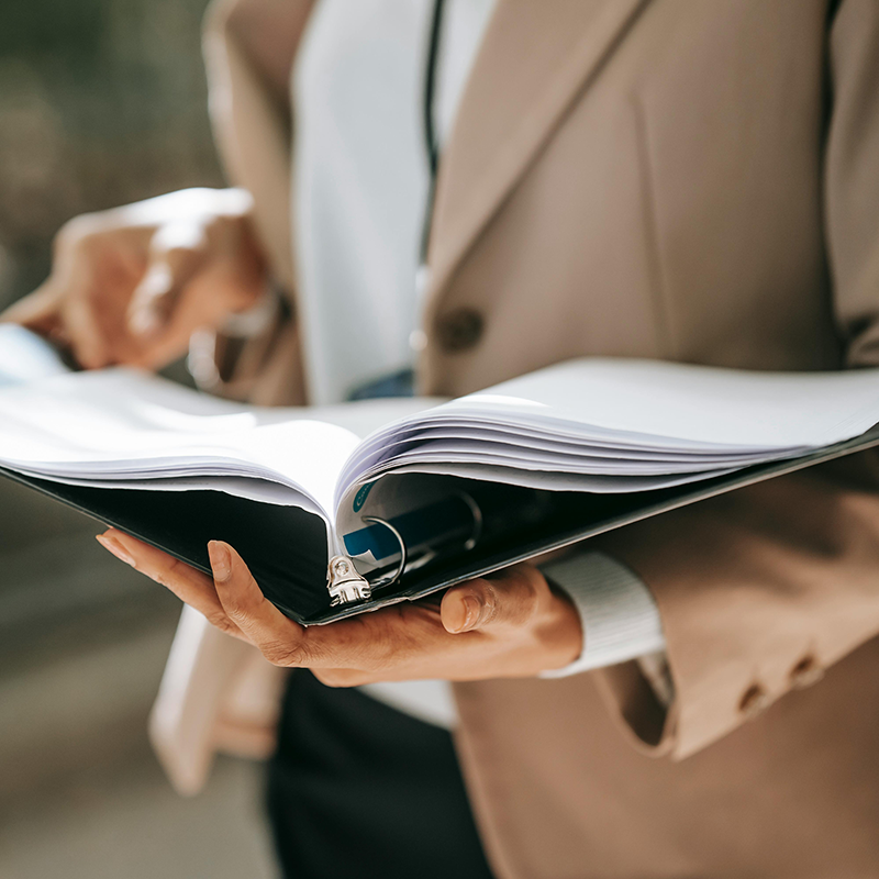 Ausschnitt einer Dame mit Mappe in der Hand