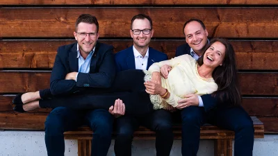 Gesellschafter der Unternehmensgruppe auf einer Holzbank